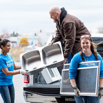 Restore volunteers unloading a sink and window screens from a truck 
