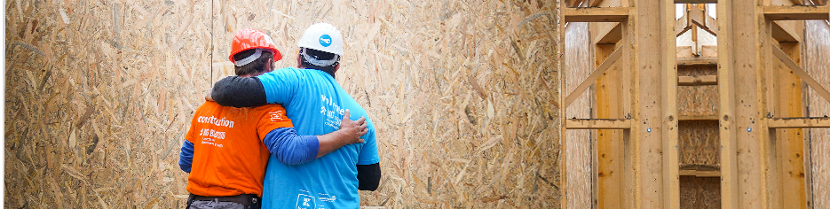 two habitat for humanity volunteers hugging appreciating the work they have completed so far
