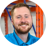 Chris wearing a red shirt and black zip up sweater 